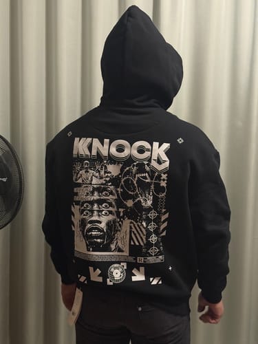Reviewer seen from behind wearing the black Embrace the Struggle hoodie, showing the large graphic.