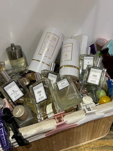 Reviewer's Inspired By Imagination - 397 perfume bottle shown within a large, varied collection of other fragrances in a basket.