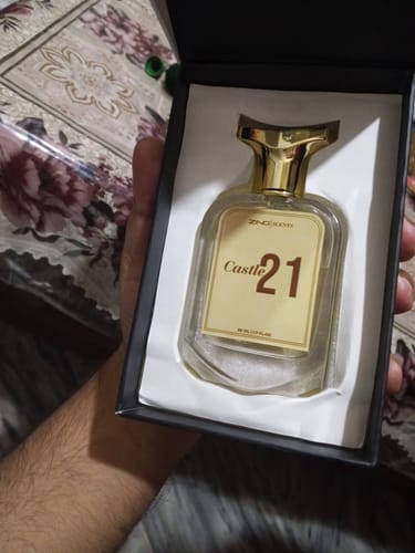 Customer holding the open black box for Castle 21, showing the fragrance bottle with a gold cap inside.