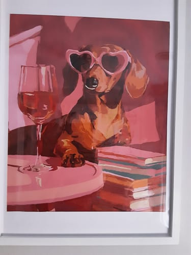 Customer's finished and framed 'Dachshund in pink' paint by number painting on display.