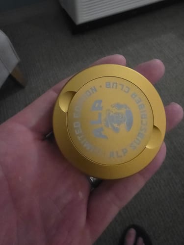 Reviewer holding a gold, limited edition container for their Mountain Wintergreen Nicotine Pouches.