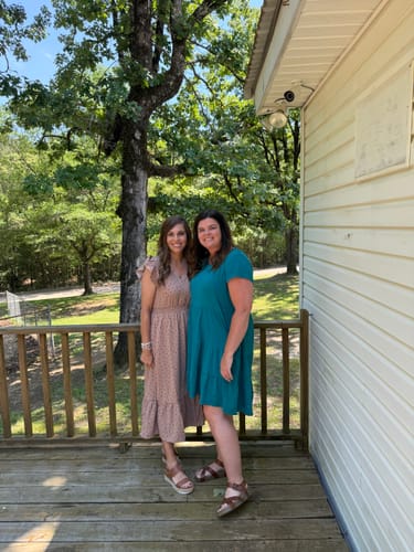 Customer wearing the Polka Dottie Ruffle Trim Midi Dress, standing outdoors on a deck with another person.