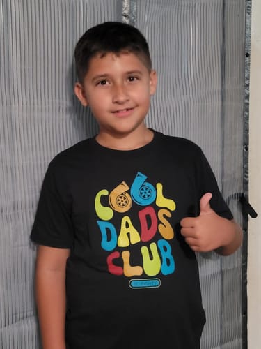 Customer wearing the black 80Eighty® Youth Cool Dad Shirt with its colorful graphic and giving a thumbs up.
