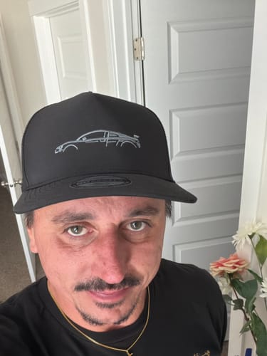 Customer wearing the black DCG89 Hat with a silver embroidered car outline on the front.