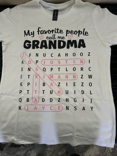 A reviewer's personalized 'Grandma's Favorite People' word search shirt laid flat to display the full design.