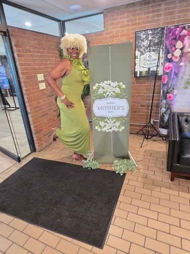 Customer showing a side view of the green Naked Ruffle Halter Maxi Dress while posing playfully.