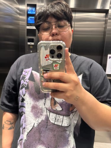 Cliente tomándose una selfie en un espejo, usando la camiseta negra Nightmare 094 con un estampado morado grande.
