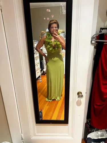 Reviewer taking a mirror selfie in the lime-green Naked Ruffle Halter Maxi Dress.