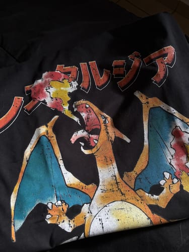 Primer plano de la camiseta negra Inferno 006 de un cliente, que muestra un gráfico de dragón naranja de estilo retro con texto en japonés.