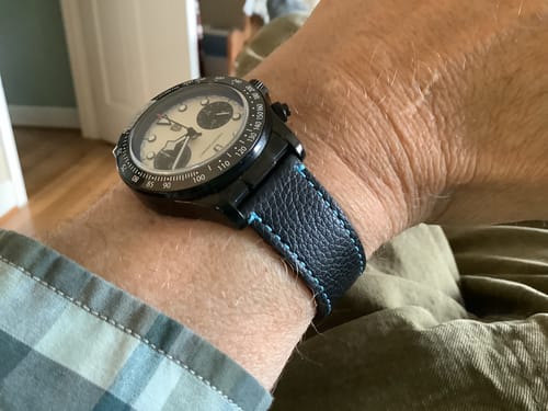 Customer's wrist wearing the dark Leather Tapered Space Green strap with contrasting blue stitching on a black watch.