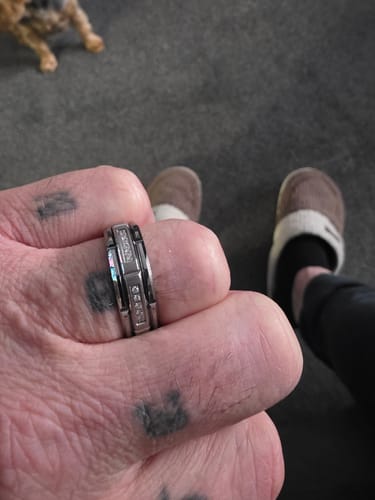 Customer's hand in a close-up, wearing the Kaelen ring with its brushed center and zircon inlays.