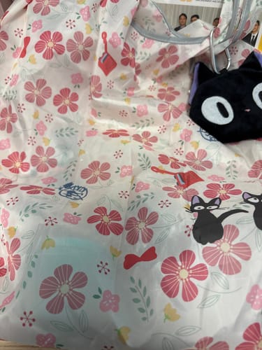 Customer's Kiki's Delivery Service tote, unfolded to show its floral pattern and attached black Jiji pouch.