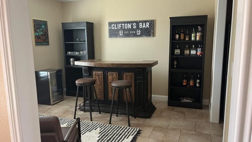 Reviewer's personalized Family Bar Rustic Sign hanging on the wall of their home bar.