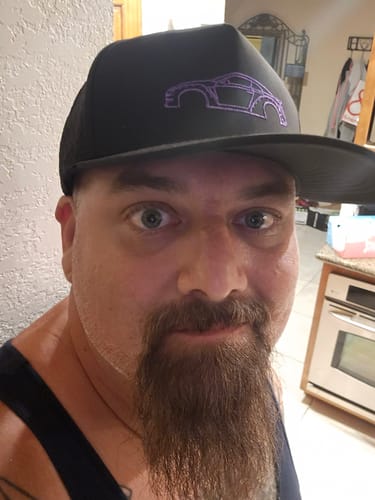 Customer wearing the black 80Eighty DCG88 Hat, showing the purple stitched car logo on the front panel.