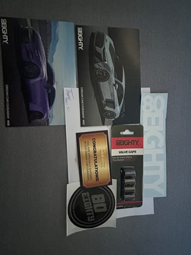 Customer's 80Eighty Valve Stem Caps in the package, displayed with stickers and car giveaway information.