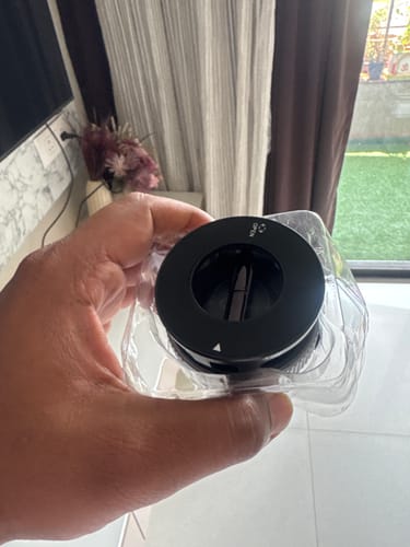 A customer's hand holds the black 360° MagPro Magnetic Phone Holder in its clear packaging.