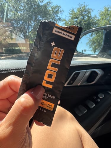 Customer holding an opened packet of SuperCharged Honey inside a car.