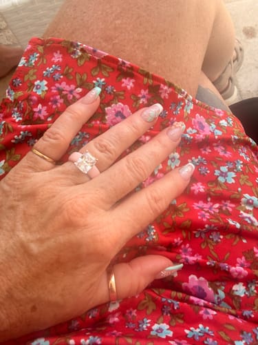 Reviewer's hand wearing the Silicone Ring, featuring a large emerald-cut stone on a light pink band.