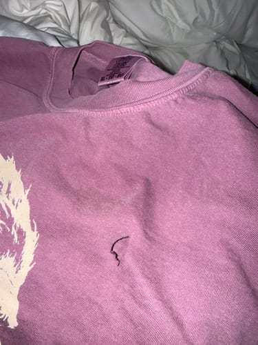 Customer's Blowing Wishes T-Shirt shown with a small cut on the front, related to the review about opening the package.