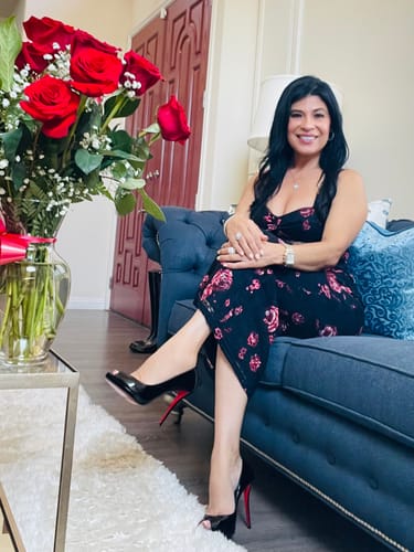 Reviewer seated on a couch in the navy floral Cerelise Lace Maxi Dress, showing its comfortable fit.