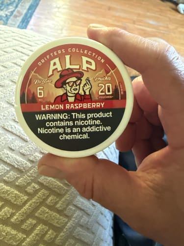 Customer holding a white, round can of Drifters Lemon Raspberry Nicotine Pouches.