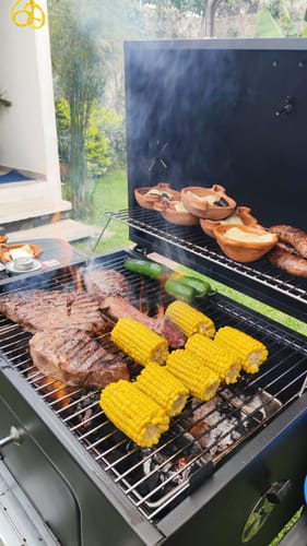 Cliente asando la Arrachera Marinada en una parrilla junto a elotes y verduras.