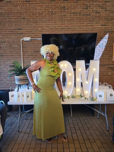 Reviewer posing in the green Naked Ruffle Halter Maxi Dress, showing the fit from another angle.