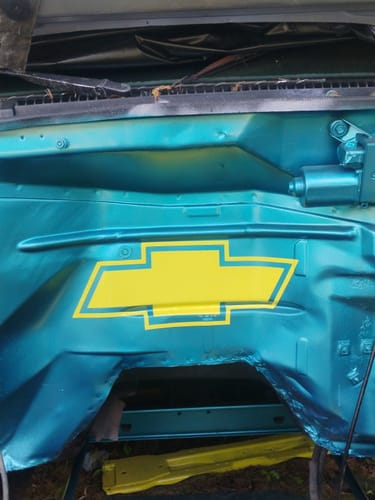 Customer's yellow custom logo decal in the shape of a Chevrolet logo, applied to a teal engine bay.
