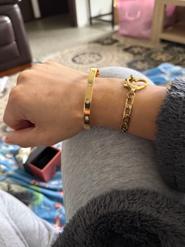 Customer wearing the gold Cecelia Stainless Steel Bangle on their wrist, showcasing its fit and stone details.