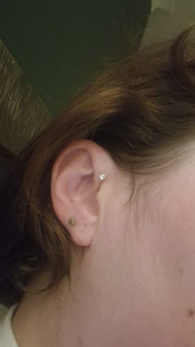 Customer wearing the Midi Solitaire flatback Gold earring in a helix piercing.