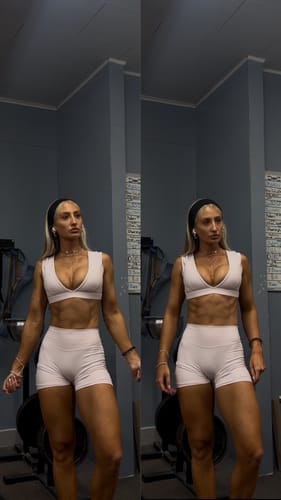 Reviewer standing in a gym wearing a light-colored workout set, showing the fit of the Amore Scrunch Shorts.