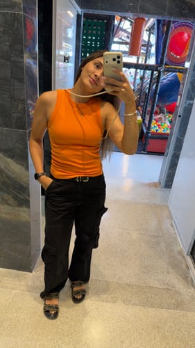 Cliente mostrando a case com alça Odara na cor creme em uma selfie no espelho.