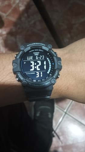 Un cliente mostrando el reloj Casio Vintage negro en su muñeca, con la pantalla digital iluminada.