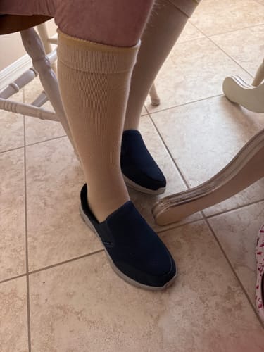 Customer wearing the beige Eucalyptus Lyocell Compression Socks on their lower legs with blue slip-on shoes.