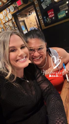 Reviewer wearing the sheer black mesh top while smiling for a photo with a friend.