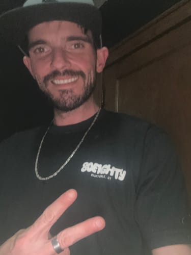 Customer smiling while wearing the black 80Eighty Lil’ Sparky Shirt.