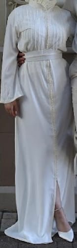 Reviewer wearing the white Kaftan Liam with its detailed embroidery and matching belt.