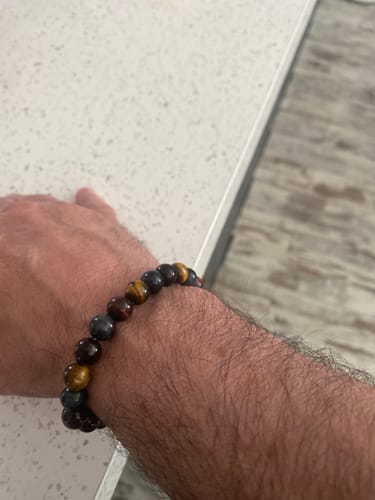 Un client porte à son poignet le bracelet 'Oeil Multiple' aux perles multicolores.