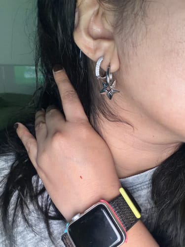 Close-up of a reviewer wearing the silver Astrology Star Hoop Earring in their ear.