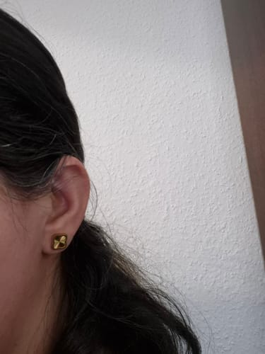 Close-up of a reviewer wearing the gold Celine Clover Earring.