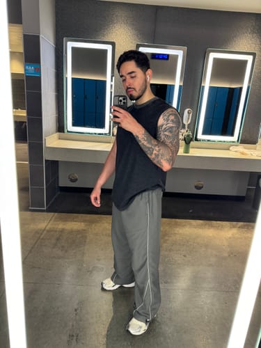 Reviewer in a gym wearing grey, baggy Foundation Track Pants, showing their fit.