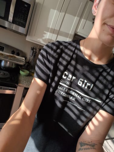 Customer wearing the black 80Eighty® Women's Car Girl Shirt with white text in a kitchen.
