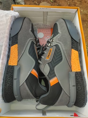Customer's overhead view of the new grey URbanart Play 3 sneakers with orange accents in the box.