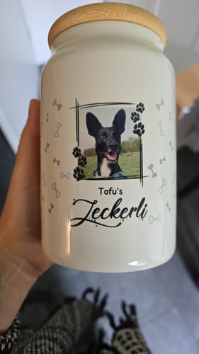 Ein Kunde hält die personalisierte Leckerlidose mit einem Foto seines Hundes Tofu.