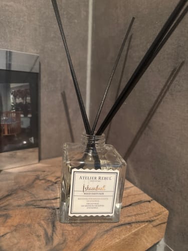 Recensent's Istanbul Geurstokjes in de vierkante fles, geplaatst op een houten ondergrond.