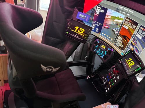 Customer's black HYBRID Cockpit in an advanced sim racing setup with a curved monitor and racing seat.