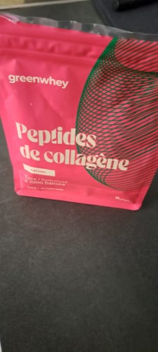 Un client montre le sachet rose de Peptides de Collagène posé sur un plan de travail sombre.