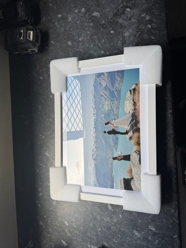 Reviewer's newly unboxed Memories Art Print in a white frame, with protective foam corners still on.