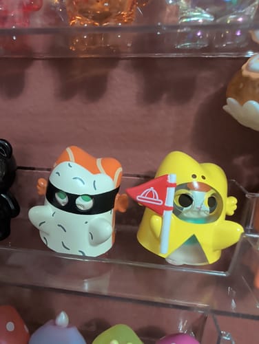Customer's two cute Jinart Ghost Cat figures on a shelf, one white with sushi on top and one yellow showing the cat inside.