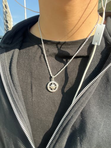 Un cliente lleva puesto el colgante Compass II con su cadena de cuerda sobre una camiseta negra.
